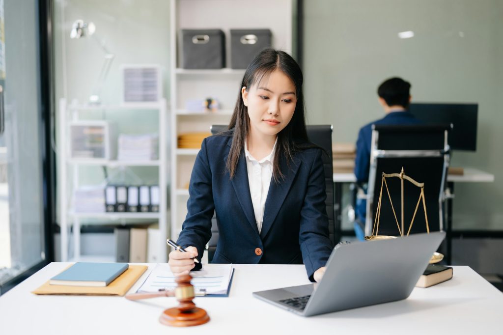 Asian woman lawyer working and gavel, tablet, laptop in front, Advice justice and law concept.