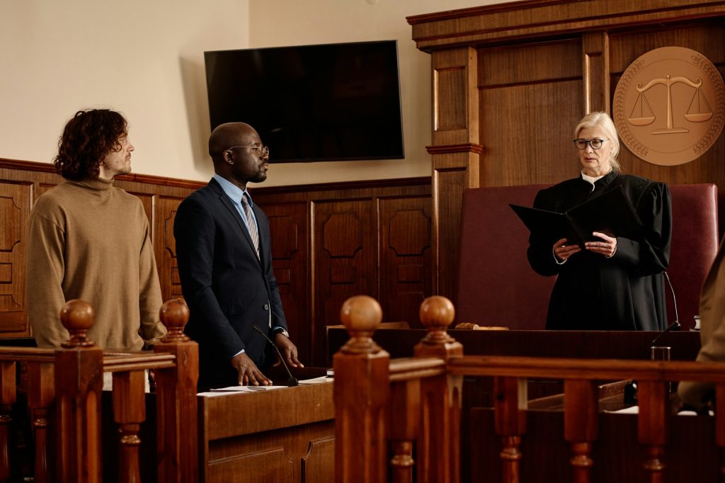 Confident female judge in black mantle passing judgement in courtroom