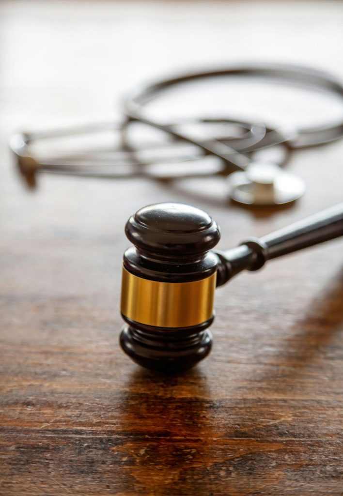 Healthcare Law. Medical stethoscope and judge gavel on lawyer office desk