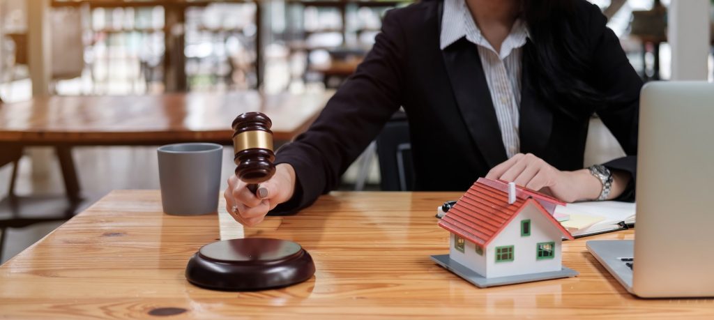Real Estate Law concept. Gavel on sounding block in hand's female judge at a courtroom, working for
